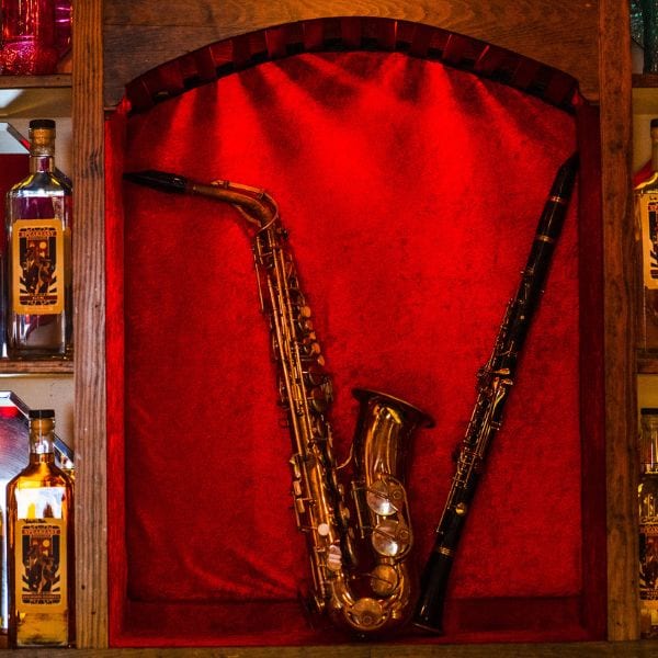 A saxophone and clarinet displayed on red velvet